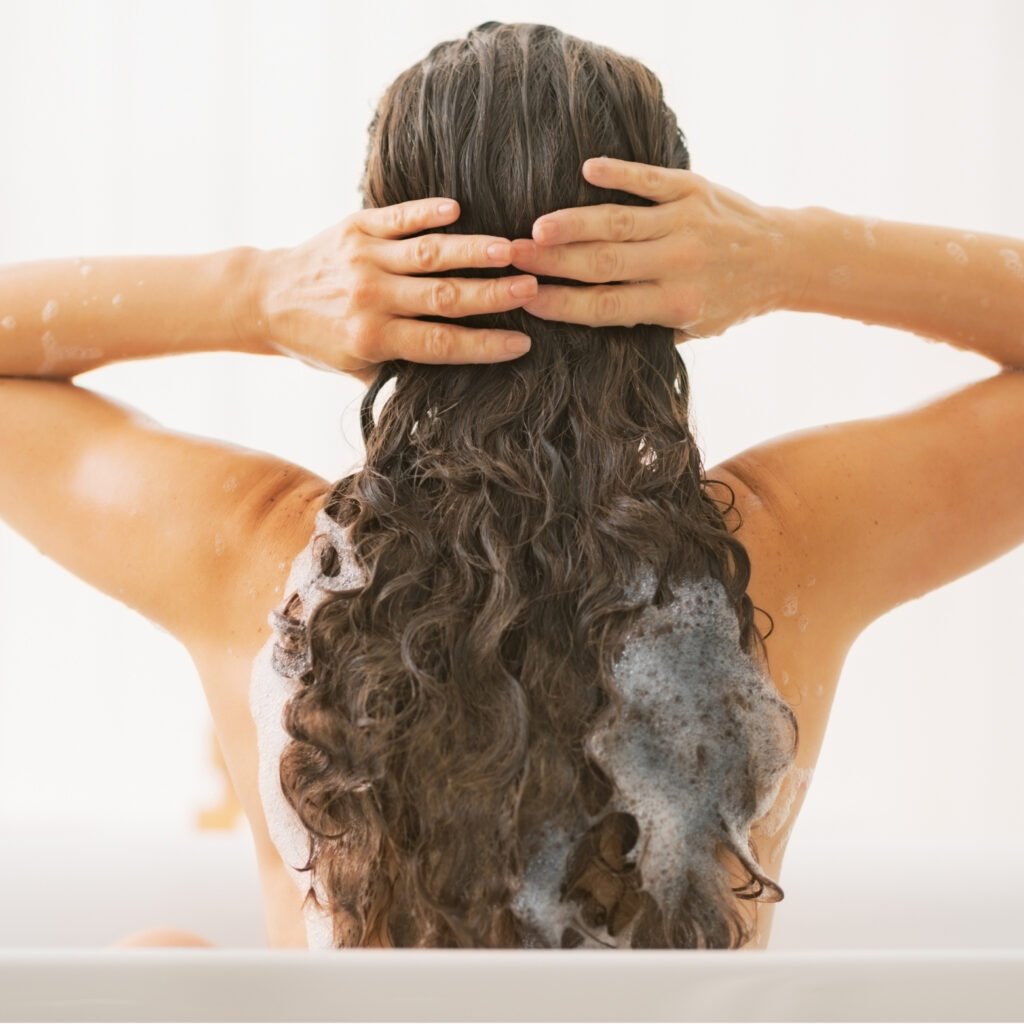 Frau bereitet ihre Locken auf den Gelcast vor mit Waschen und Pflegen
