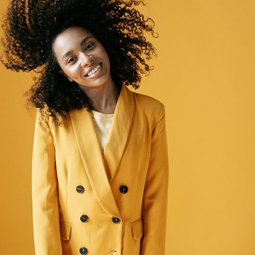 Frau mit Locken vor gelbem Hintergrund